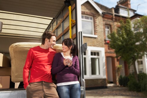 Moving crew carrying household items during a local relocation in Merton